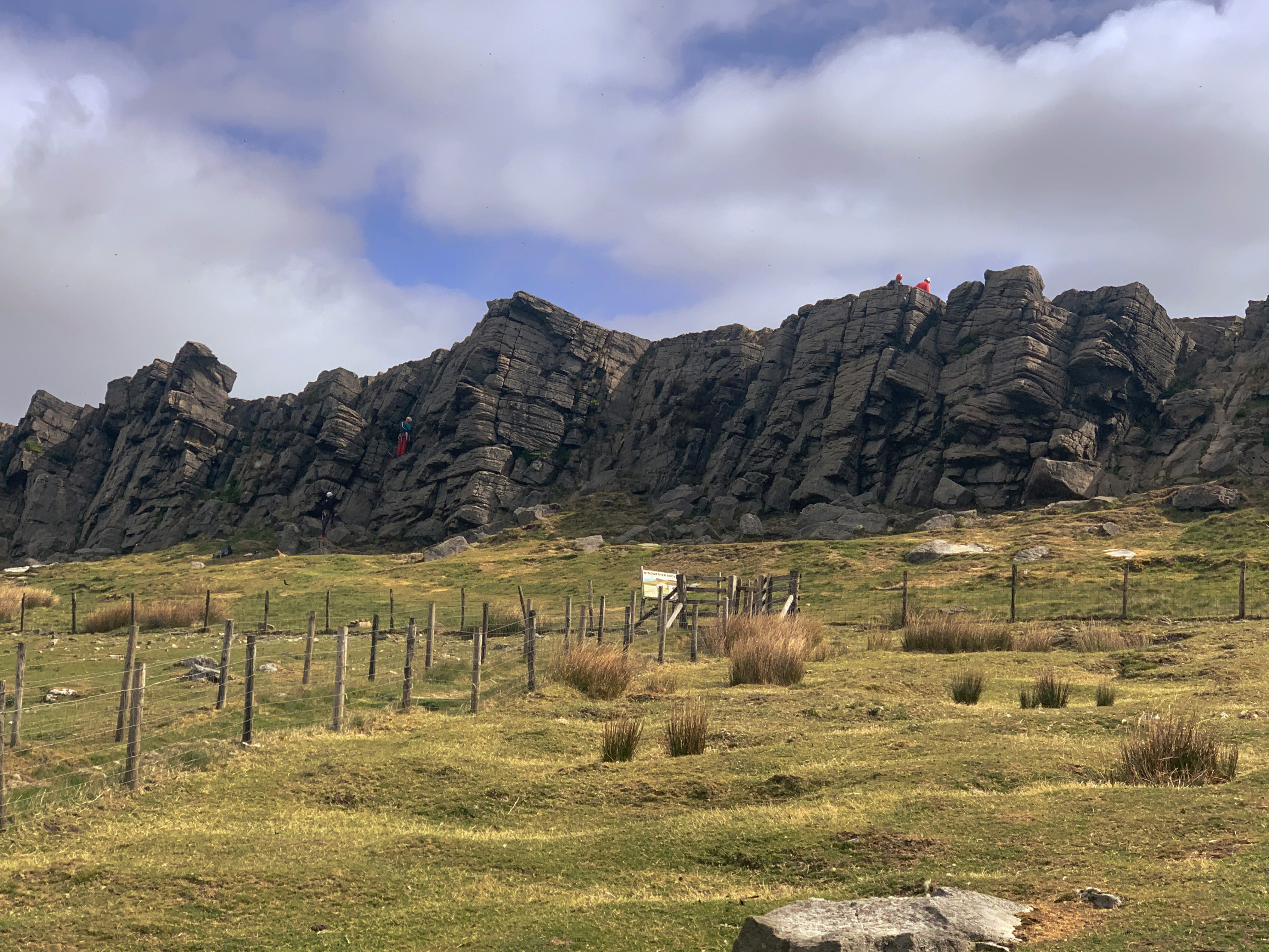 Panoramic countryside landscape of Stanage Edge, showing rugged cliffs, purple heather, and expansive valley views.